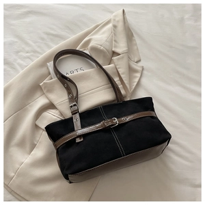 Detail of canvas shoulder bag with brown leather trim and white contrast stitching