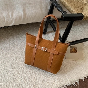 Detailed close-up of a vintage brown bucket bag with belt accents and metal buckle decor