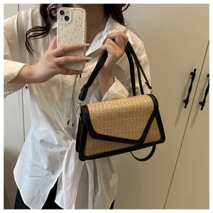Close-up of rainbow straw woven texture with black leather flap on stylish shoulder bag