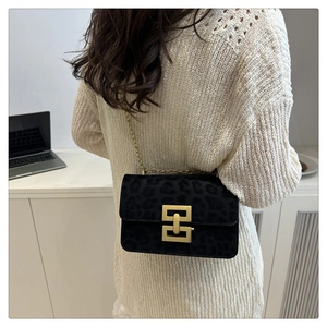 Detailed view of leopard texture crossbody bag with gold lock on a model shoulder