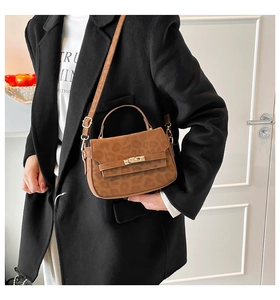 Detail of leopard print handbag with golden twist lock closure and adjustable strap