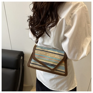 Close-up of woven rectangular shoulder bag with multicolor stripes and leather trim