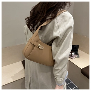 Detailed close-up of the khaki leather shoulder bag with a stylish metal clasp lock