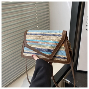 Detail of colorful woven straw texture and premium brown leather trim on crossbody bag