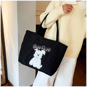 Detail der schwarzen Stepptasche mit süßem Hundeaufnäher und Our fave Stickerei