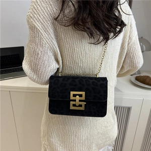 Leopard print crossbody bag with gold H-clasp and metal chain strap on model