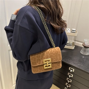Leopard print crossbody bag with gold chain strap and geometric clasp on model
