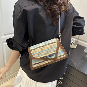 Colorful woven crossbody envelope bag with brown leather trim and golden hardware