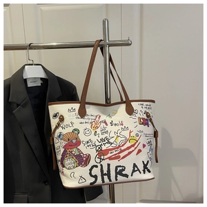 Détail du sac cabas graffiti blanc avec bordure en cuir marron et broderie ours