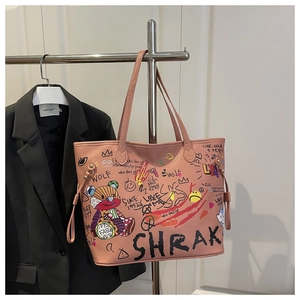 Détail du sac seau rose avec motifs graffiti ours et texture cuir grainé élégante