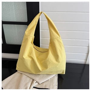 Detail van een felgele grote shopper met gladde nylon textuur en ritssluiting