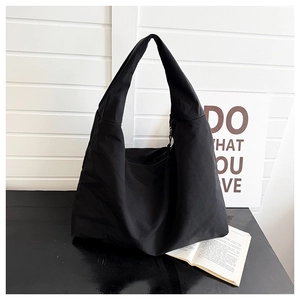 Detail van de grote zwarte canvas hobo-tas met brede riem en ritssluiting voor dames