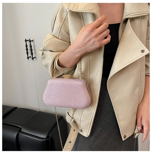 Detail of pink sequin clutch bag with gold handle and jewel clasp shown on model