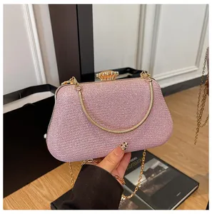 Detail of pink glitter clutch bag with crystal clasp and golden chain strap for evening events