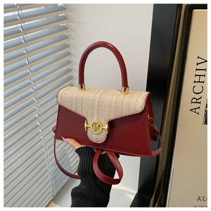 Détail du sac en cuir rouge et tweed beige avec boucle métallique dorée en forme de M