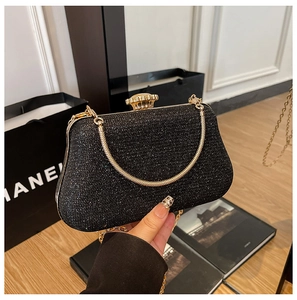Close-up of elegant black sequin clutch bag with gold chain strap and crystal clasp