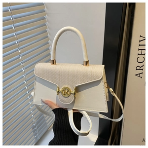 Détail du sac crème avec texture tissée et boucle dorée avec logo M en gros plan