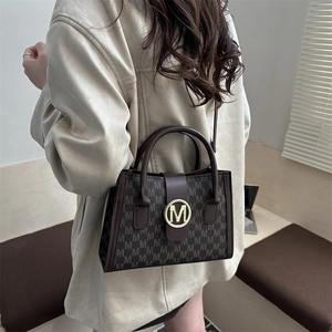 Brown monogram tote bag with gold M-buckle and leather handles for business women