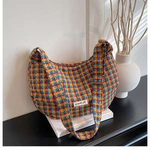 Detail of colorful houndstooth tweed bag with power off patch and metal buckle on strap