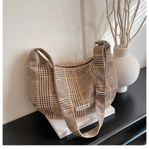 Detail of vintage houndstooth tote bag with power off label and crescent shape design