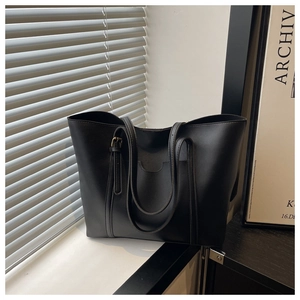 Detail of black matte tote bag with adjustable shoulder strap and U-shaped pocket