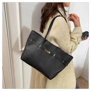 Dettaglio della borsa tote in pelle nera martellata con fibbia dorata e cinturino