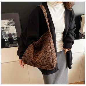 Detail view of leopard print tote bag texture and wide shoulder strap in daily usage