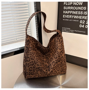 Detail view of leopard print tote bag in soft suede fabric on a metallic surface