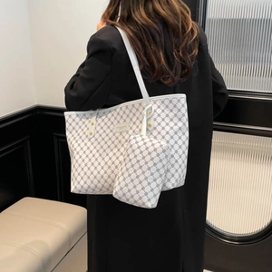 Large cream tote bag with geometric print and matching pouch shown on a model's shoulder