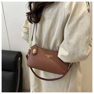 Close-up of brown lychee grain leather shoulder bag with gold twist lock and logo