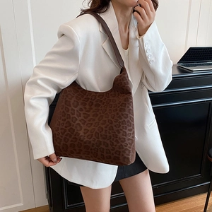 Fashionable leopard print hobo bag worn by a model in a modern office setting