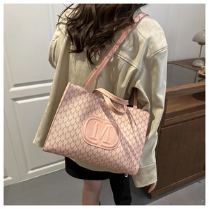 Detail of pink monogram tote bag with embossed M logo and textured leather surface