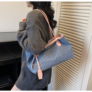 Close-up of leopard print tote bag with pink trim on a female model shoulder