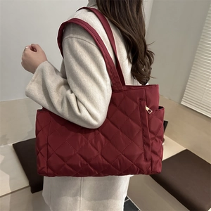 Quilted tote bag in burgundy with large capacity and elegant side zipper detail
