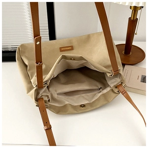 Top view of khaki canvas tote bag featuring adjustable brown straps and internal pocket