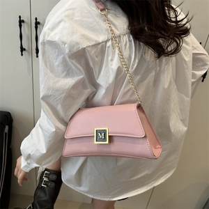 Pink PU leather crossbody bag with M buckle and gold chain strap on model