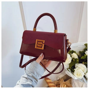 Detail of burgundy patchwork shoulder bag with vintage gold clasp and matte finish