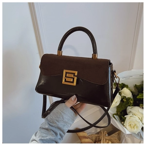 Detail of dark brown leather handbag with suede texture contrast and gold clasp