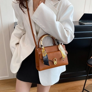 Elegant brown PU leather satchel with silk scarf handle and gold hardware on a model