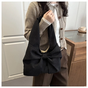 Détail du sac cabas en maille noire avec texture côtelée et grand nœud décoratif