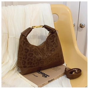 Dettaglio borsa marrone leopardata con goffratura di lettere e fibbia metallica a H