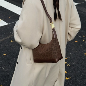 Borsa Hobo marrone con stampa leopardata e tracolla in pelle regolabile indossata in strada