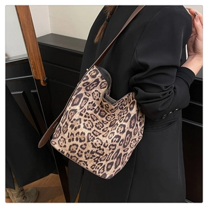 Détail du sac cabas léopard avec bandoulière en cuir marron et texture douce en daim