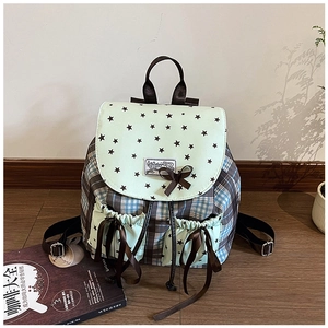 Detail of plaid and star print backpack with silk ribbon bow and drawstring