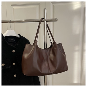 Detail of dark brown tote bag in faux leather with vertical stitching and large capacity