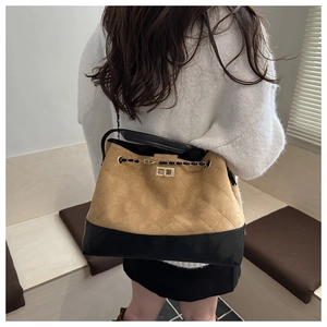 Detail of checkered bucket bag with gold clasp and chain strap in contrast colors