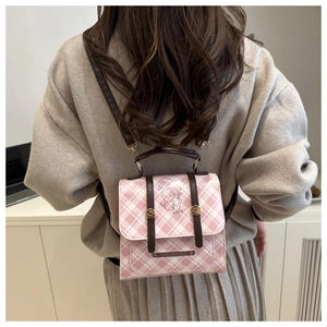 Rosa karierter Mini-Rucksack mit Hunde-Illustration auf dem Rücken eines Models