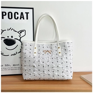 Détail du sac cabas blanc à texture froissée, imprimés nœuds noirs et fermoir doré chic