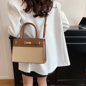 Chic brown leather and beige canvas Kelly bag with gold buckle and crossbody strap