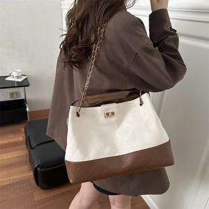 Vintage quilted canvas and leather tote bag with gold chain strap on model shoulder